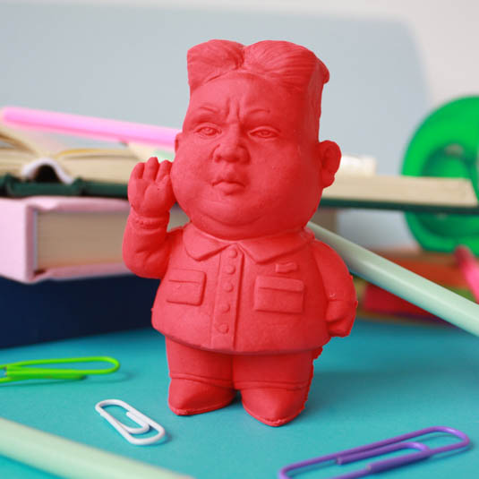Red rubber dictator eraser saluting, surrounded by paper clips
